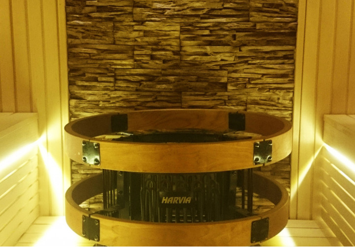 Sauna con parete frontale in vetro e rivestimento in pietra