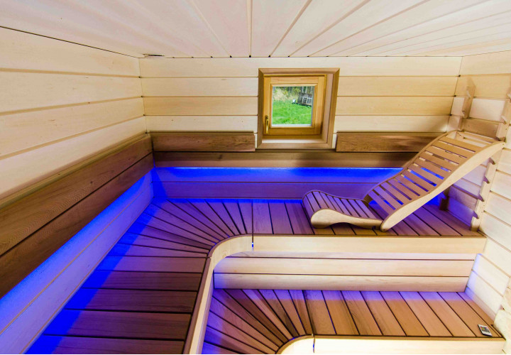 Sauna con riscaldatore ad accumulo di calore e focolare esterno