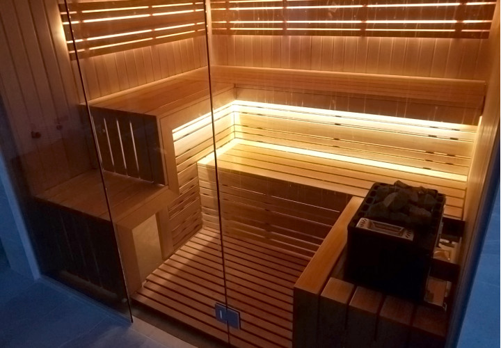 Sauna con parete in vetro e vista sulla piscina