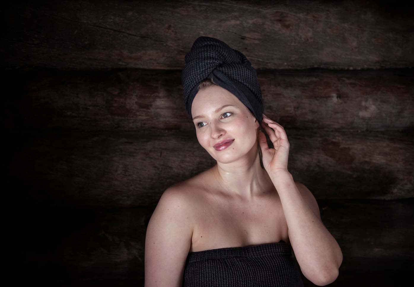 Donna in sauna con asciugamano per capelli