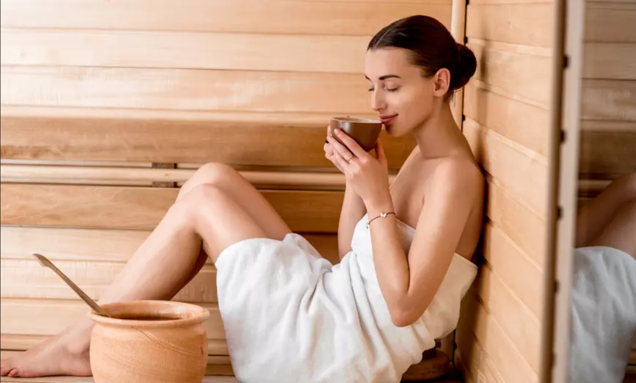 Una donna beve il tè in una sauna