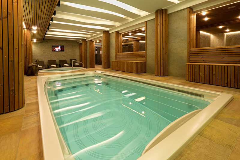 Piscina idromassaggio USSPA interna installata in un'area benessere con zona relax separata.