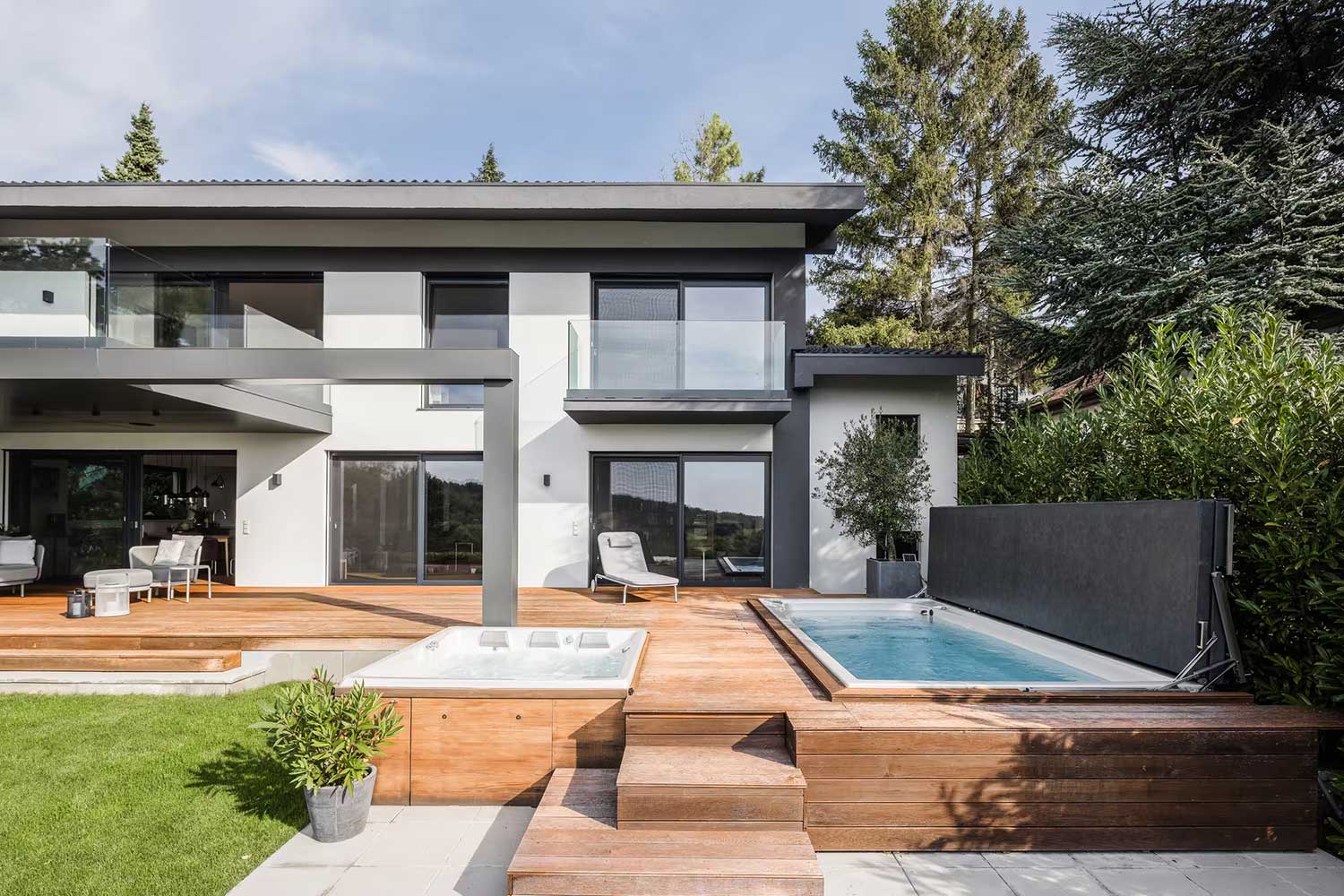 Piscine USSPA spa e swim spa con coperture rialzate installate accanto alla terrazza di una casa moderna.