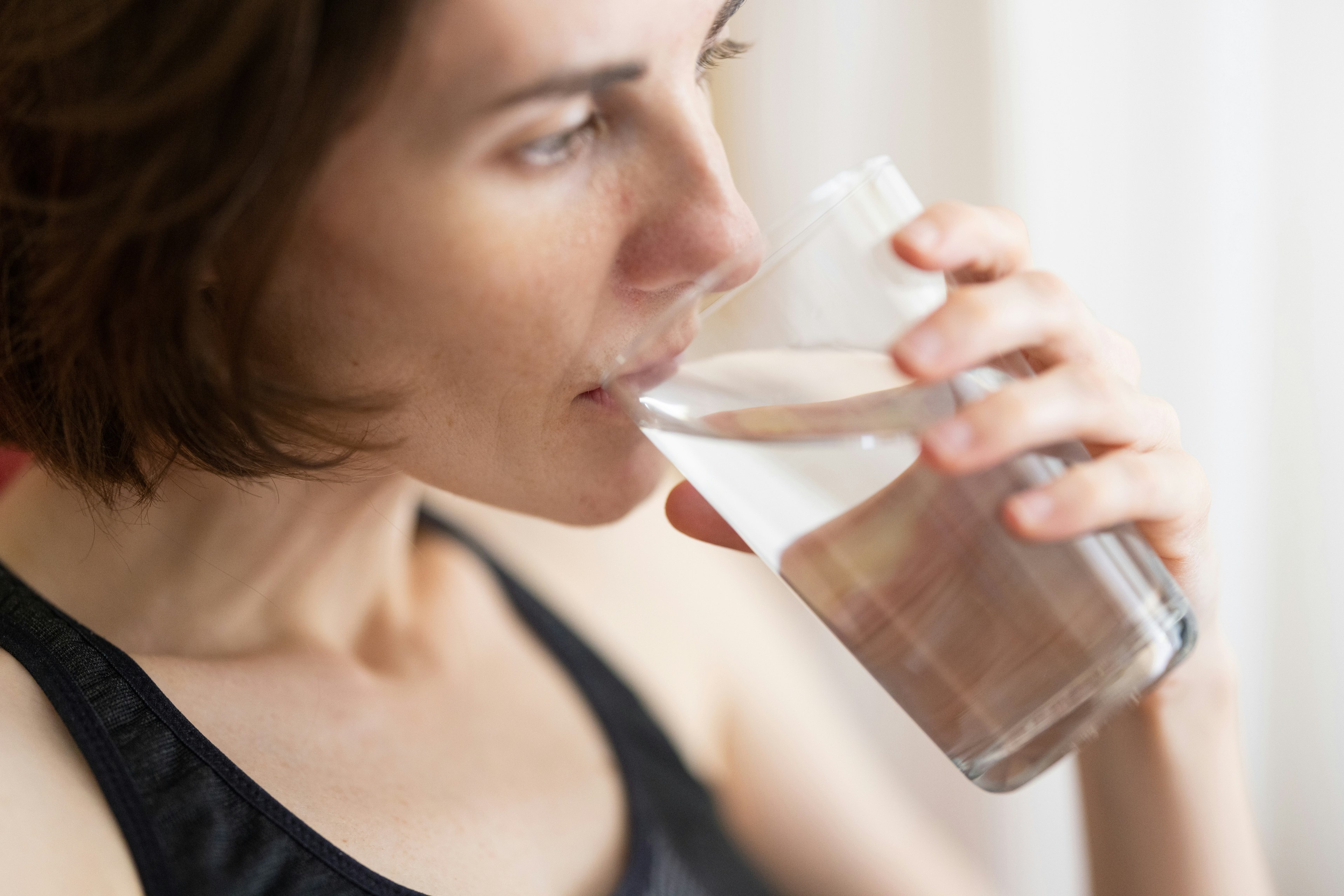 Ragazza che beve un bicchiere d'acqua