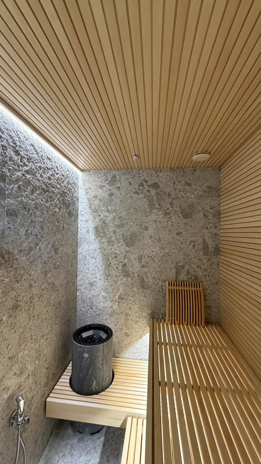 Sauna con finiture in legno e pietra