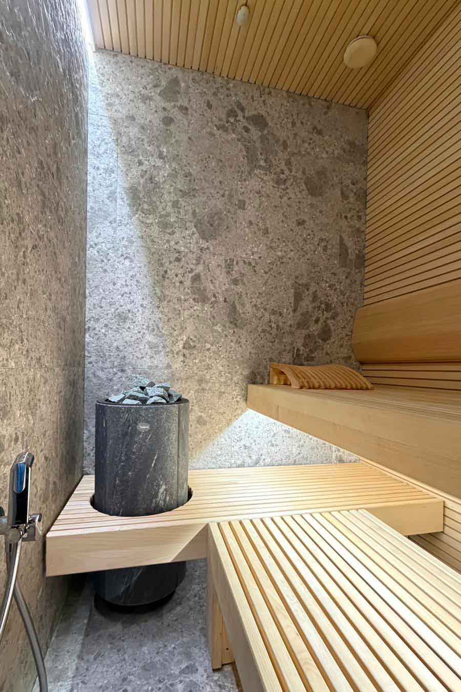 Sauna con finiture in legno e pietra